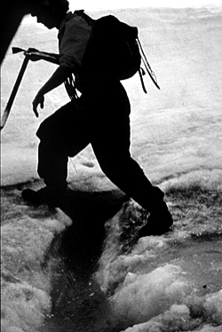 A researcher (woman) walking on a glacier